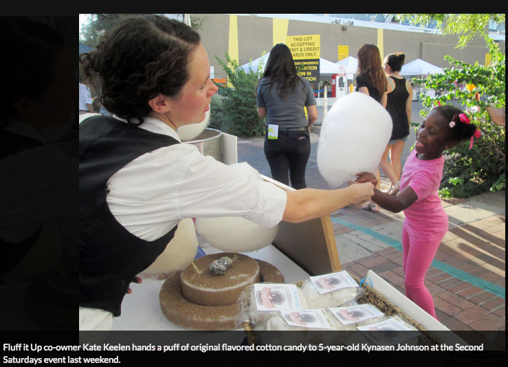 Kate hands cotton candy to girl at a public event